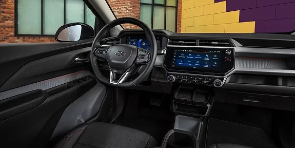 2027 Chevrolet Bolt RS interior dashboard showing the touchscreen, steering wheel, and red accent trim