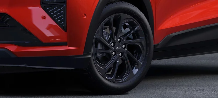 Close-up of the 2027 Chevrolet Bolt RS front wheel and lower body showing the 17-inch black wheels