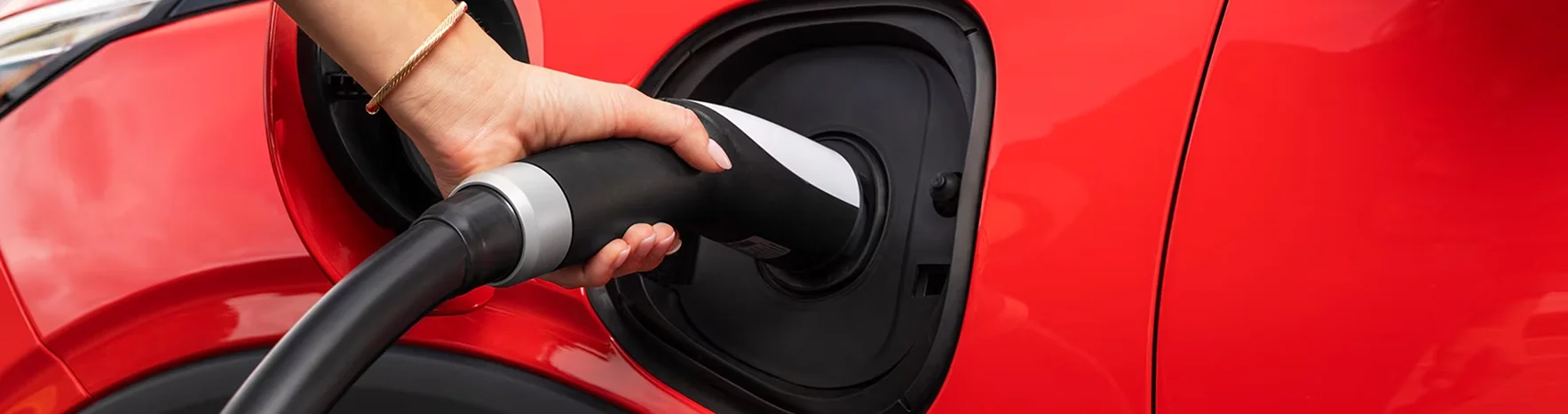 2027 Chevrolet Bolt plugged into a public DC fast charging station in a parking lot