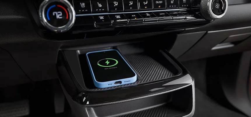 Smartphone placed on the wireless charging pad inside the 2027 Chevrolet Bolt center console